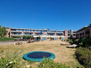 un bâtiment avec une grande piscine en face d'un bâtiment dans l'établissement Duinroos, à Nes