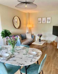 a living room with a table and a couch at Les rives de l’Indre. Parking gratuit. Lit 160CM in Châteauroux