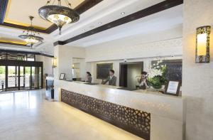 a lobby of a hotel with people sitting at a counter at Danat Al Ain Resort in Al Ain