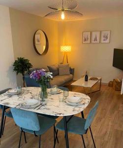a living room with a table with chairs and a couch at Les rives de l’Indre. Parking gratuit. Lit 160CM in Châteauroux