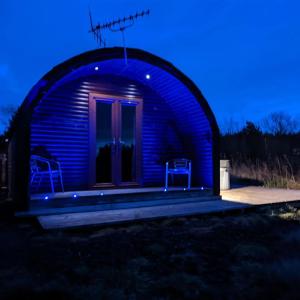 um observatório azul iluminado com duas cadeiras nele em Pond View Pod 3 With Private Hot Tub - Pet Friendly -Fife - Loch Leven - Lomond Hills em Kelty