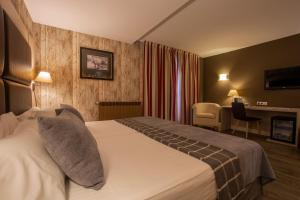 Cette chambre comprend un lit et un bureau. dans l'établissement Hotel Himàlaia Soldeu, à Soldeu