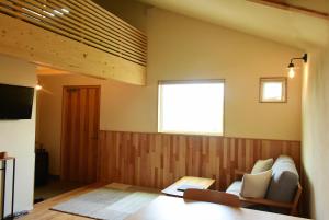mizuki natural villa في Higashikawa: غرفة معيشة مع أريكة ونافذة