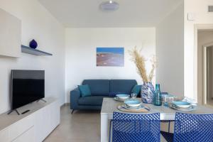 a living room with a table and a blue couch at Color Dream Residence in Monopoli