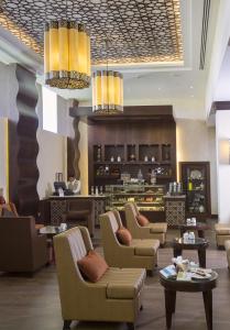 a lobby with couches and chairs and a bar at Danat Al Ain Resort in Al Ain