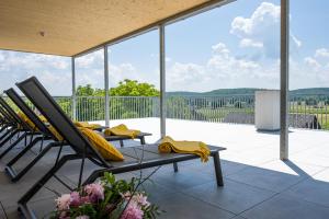 eine Terrasse mit 2 Stühlen und einer Bank auf einer Terrasse in der Unterkunft Landhotel Schwabenhof in Heiligenbrunn