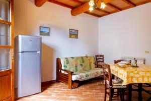 uma sala de estar com um frigorífico, uma mesa e um sofá em Oleandro - Agriturismo La Fattoria em Grosseto