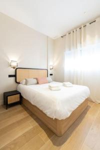 a bedroom with a large white bed with a window at Amplio y cómodo apartamento cerca Plaza Castilla in Madrid