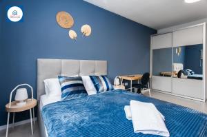 a blue bedroom with a large bed with blue walls at Design apartments in Netanya in Netanya