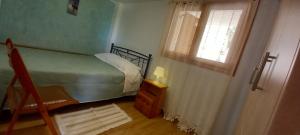 a small bedroom with a bed and a window at Porto Vito in Porto Germeno