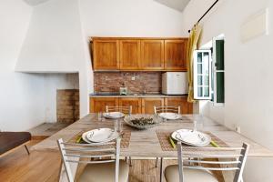 una cucina con tavolo e sedie in legno in una stanza di Casa Syrah a Palmela