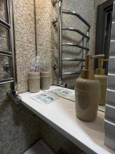 ein Badezimmer mit einem Waschbecken und einer Flasche auf der Theke in der Unterkunft Hotel Voyage Вояж in Uman