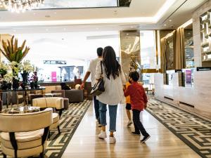una familia caminando por el vestíbulo de un centro comercial en Hyatt Regency Al Kout Mall en Kuwait