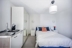 a white bedroom with a bed and a sink at Apartments Batista in Trogir