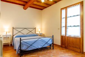 um quarto com uma cama e uma grande janela em Oleandro - Agriturismo La Fattoria em Grosseto