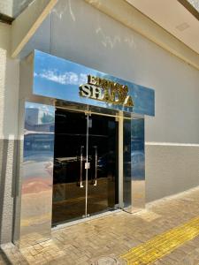 a sign on the front of a building with a glass door at Residencial Shalfa in Foz do Iguaçu