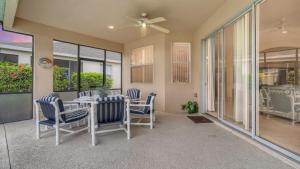 comedor con mesa, sillas y ventanas en 509pd- Perfect Pool Time Villa, en Haines City