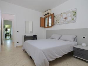 ein Schlafzimmer mit einem großen weißen Bett und einem Tisch in der Unterkunft PALMA RESIDENCE - Dependance LE MAGNOLIE in Marco Simone