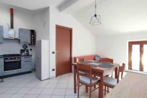 een keuken met een tafel en stoelen en een koelkast bij Casa Vacanze Como in Casnate con Bernate