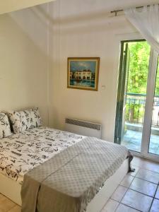 a bedroom with a bed and a large window at Seaside escape in Ormos Panagias