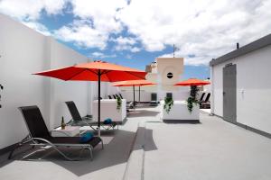 un patio con sillas y sombrillas en la azotea en Apartamento La Estrella 4, en Arrecife
