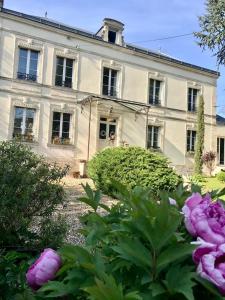 uma grande casa branca com flores em frente em CLOS REMY Maison d'hôtes em Précy-sur-Oise