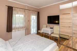 1 dormitorio con 2 camas, mesa y TV en Kék Lagúna Vendégház, en Balatonfüred