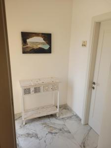 a white room with a table and a painting on the wall at Azure W B&B in San Lawrenz