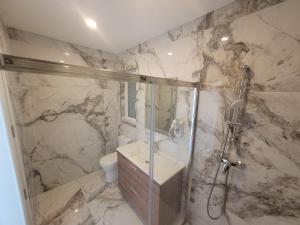 a bathroom with a shower and a sink and a toilet at Azure W B&B in San Lawrenz
