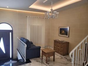 a living room with a blue chair and a dresser at Azure W B&B in San Lawrenz