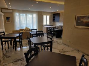 a restaurant with tables and chairs and a kitchen at Azure W B&B in San Lawrenz