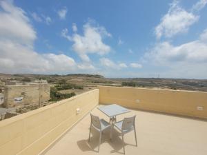 a table and two chairs on a balcony with a view at Azure W B&B in San Lawrenz