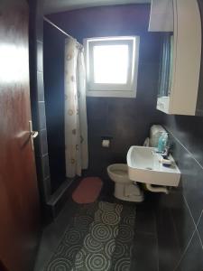 ein Bad mit einem WC, einem Waschbecken und einem Fenster in der Unterkunft Apartmani Konstantin in Višegrad