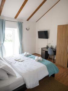 a bedroom with a large white bed and a desk at Holiday Home Vera in Malinska