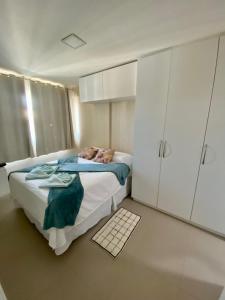 a bedroom with a bed and white cabinets at Apto vista mar e pé na areia no Beach Way a 300m do Beach Park in Aquiraz