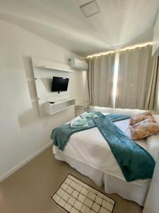 a small bedroom with a bed and a television at Apto vista mar e pé na areia no Beach Way a 300m do Beach Park in Aquiraz