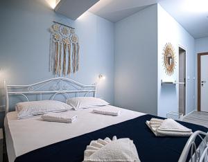 Un dormitorio azul con una cama grande con toallas. en GUEST HOUSE RHEA / КЪЩА ЗА ГОСТИ РЕЯ, en Balchik