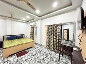 a bedroom with a bed and a television in it at Pet Friendly Cottage Room in Kolkata in Kolkata