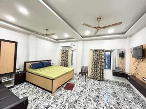 a bedroom with a bed and a flat screen tv at Pet Friendly Cottage Room in Kolkata in Kolkata