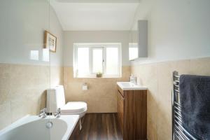 ein Badezimmer mit Waschbecken und Toilette und einem Fenster in der Unterkunft Stunning 5 bed house in Chapel Allerton, sleeps 9 in Moortown + 12 Fotos