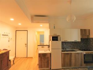 a kitchen with white appliances and wooden floors at Michy's house in Sestri Levante +15 photos
