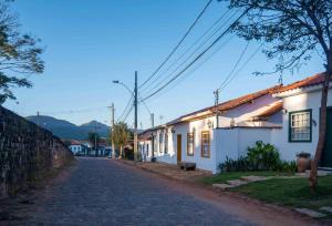 een geplaveide straat in een stad met witte huizen bij Lofts Villa da Serra in Tiradentes