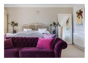um sofá roxo com almofadas roxas numa sala de estar em Hewas Water House - Private Pool, Hot Tub & Games Room em Grampound