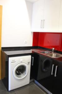 a kitchen with a washing machine and a sink at Casa da Dona Palmira in Fátima