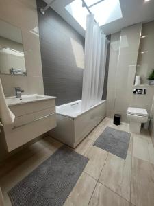 a bathroom with a tub and a sink and a toilet at SW - Four - 3 in London