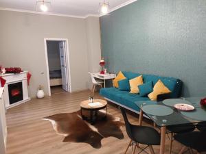 a living room with a blue couch and a table at Piata's Hidden Apartment in Braşov