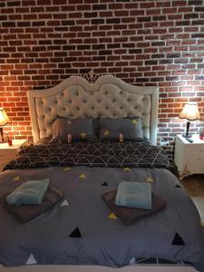 a large bed in a room with a brick wall at IZZY'S HIDDEN APARTMENT in Braşov