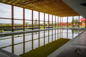 a pool of water in a building with windows at Nosztalgia Resort in Vlăhiţa