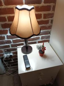 a table with a lamp and a remote control on it at IZZY'S HIDDEN APARTMENT in Braşov