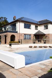 a house with a swimming pool in front of a house at Hewas Water House - Private Pool, Hot Tub & Games Room in Grampound +22 photos
